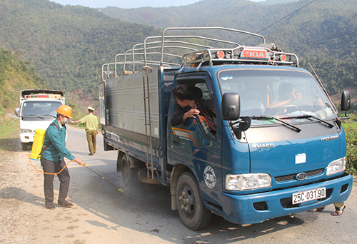 Lực lượng liên ngành phun tiêu độc, khử trùng các phương tiên trên Quốc lộ 4H (tại bản Phiêng Kham, xã Bum Nưa).