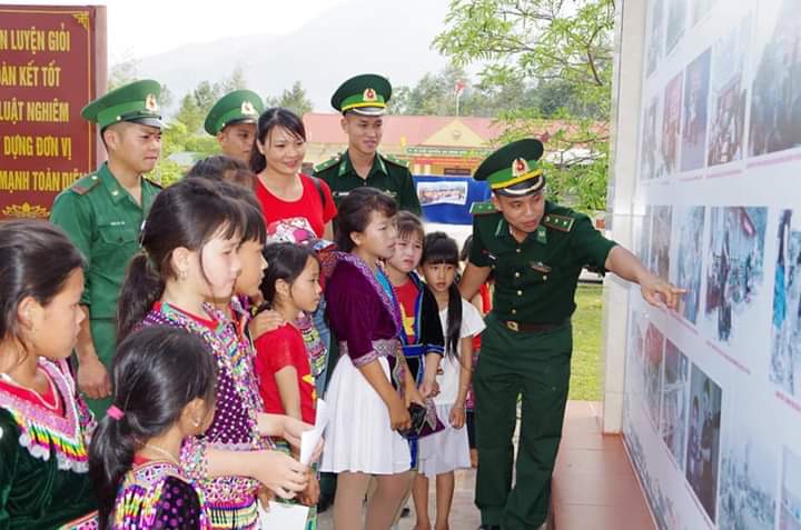 Cán bộ chiến sỹ Đồn Biên phòng Pa Tần giới thiệu về các hoạt động cho học sinh trên địa bàn xã khi đến tham quan qua bảng ảnh. 