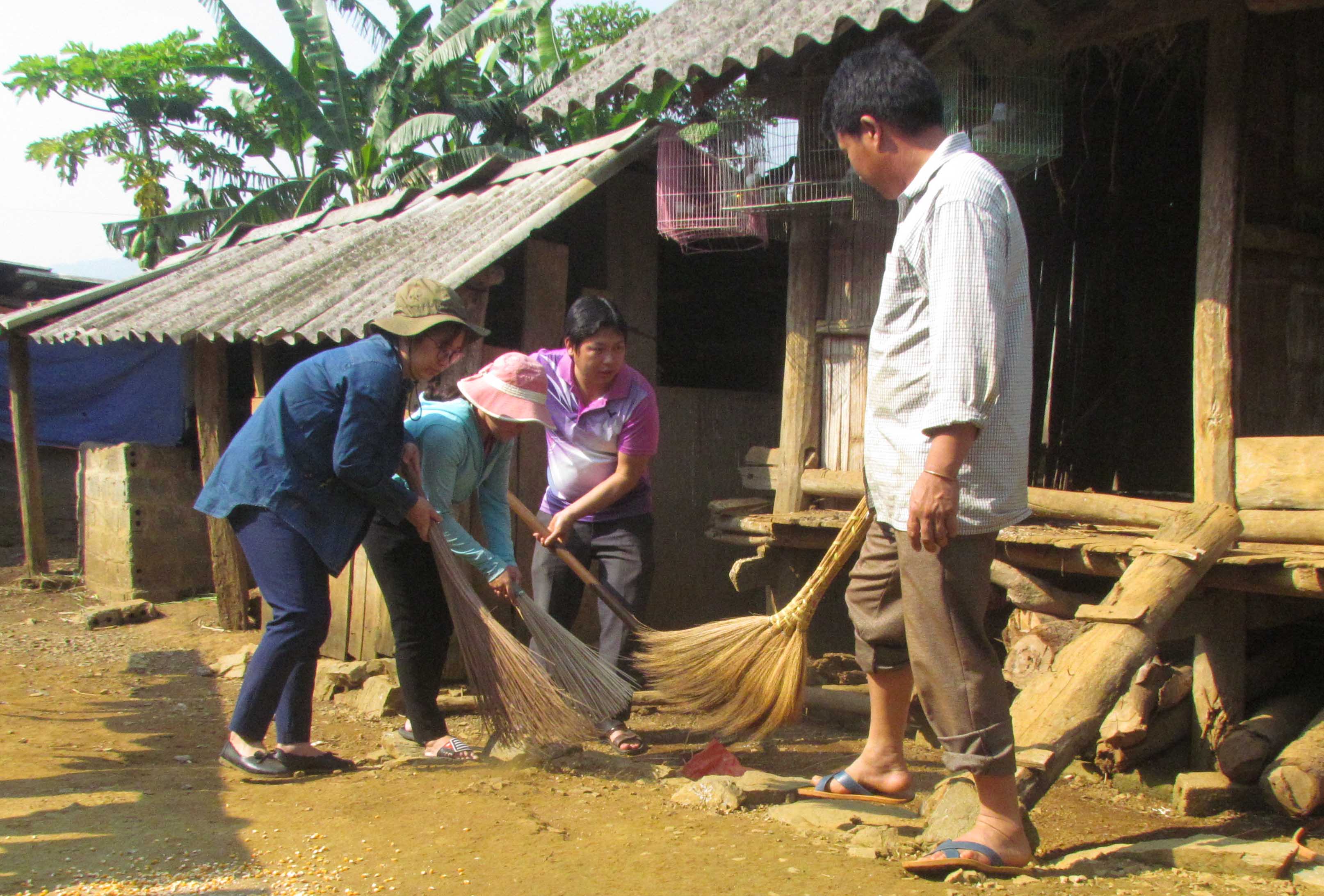 Nhân viên Phòng Kinh tế thành phố Lai Châu cùng người dân bản Lùng Thàng giúp gia đình ông Dì A Phủ vệ sinh nhà cửa, khu vực chăn nuôi thực hiện mô hình “Nhà sạch, vườn đẹp”.