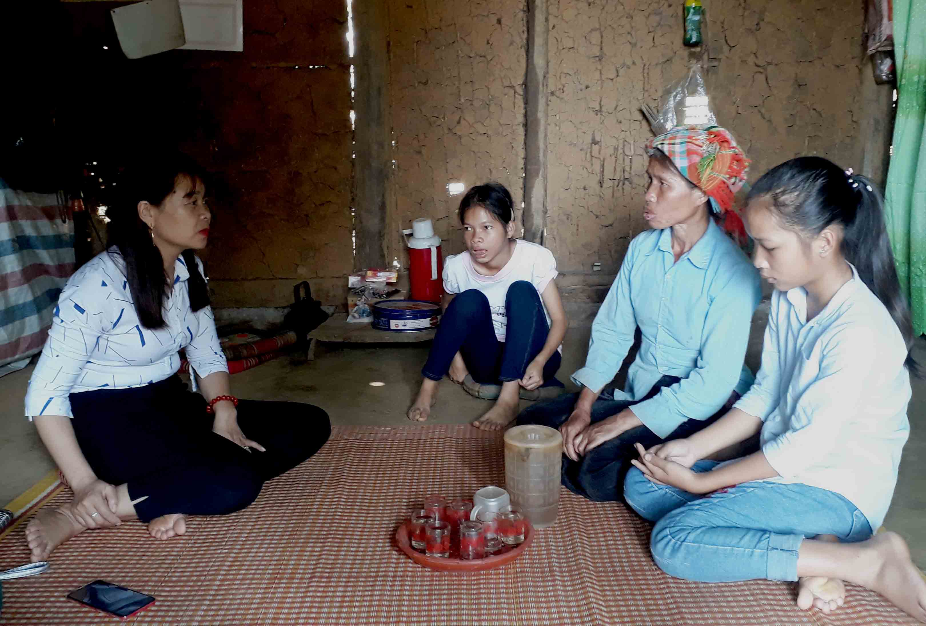 Chị Hương- Cán bộ Hội Nông dân xã Mường Cang trò chuyện, chia sẻ với hoàn cảnh đáng thương của 3 mẹ con chị Lìm Thị Mịnh- bản Pom Míu, xã Mường Cang (Than Uyên). 