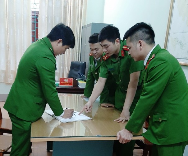 Thiếu tá Nguyễn Mỹ Đồng trao đổi nghiệp vụ với anh em trong đội. 