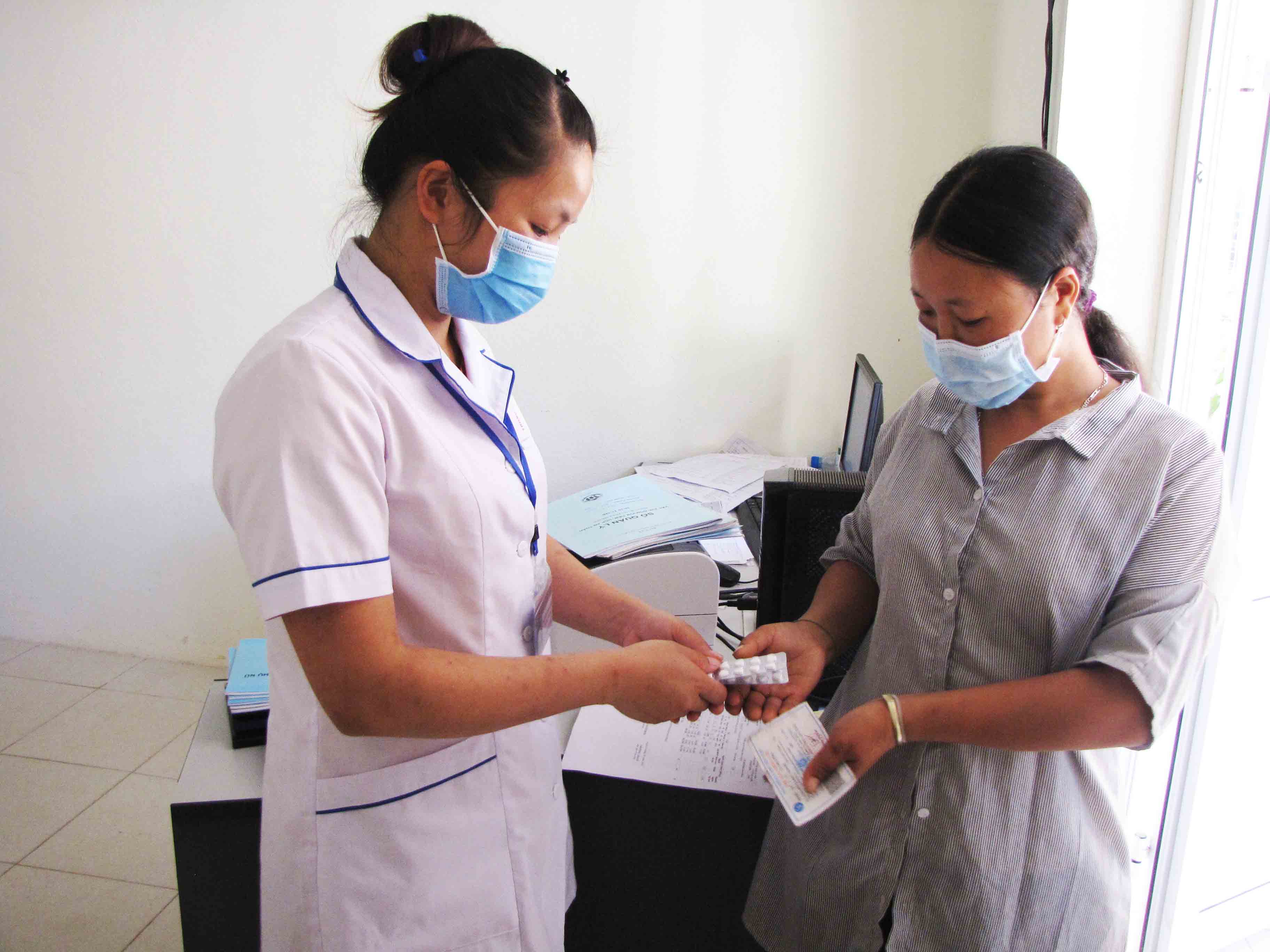 Cán bộ y tế Trạm y tế xã Hua Bum cấp phát và hướng dẫn người dân sử dụng thuốc