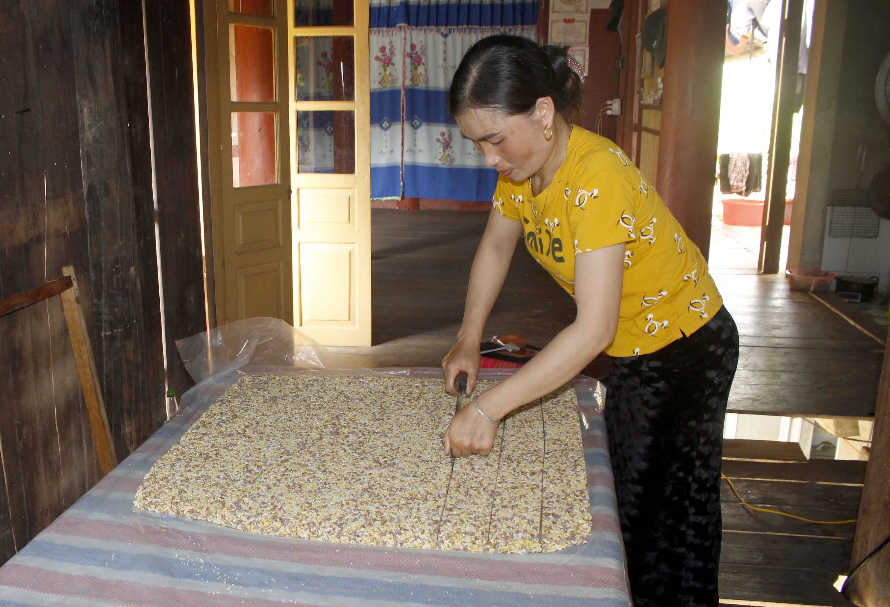 Chị Nùng Thị Nguyên- bản Pom Bó, xã Mường Cang (huyện Than Uyên) đang cắt bánh “Khẩu xi” thành từng miếng nhỏ. 
