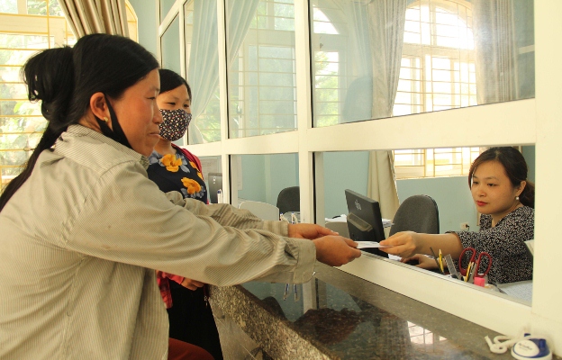 Người dân đến làm thủ tục cấp thẻ bảo hiểm y tế tại Bảo hiểm Xã hội huyện Mường Tè .