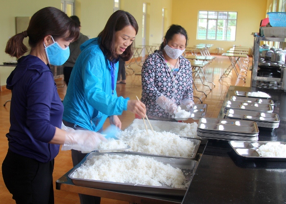Cô giáo Hoàng Kim Oanh (ở giữa) kiểm tra nhân viên nhà bếp chuẩn bị bữa ăn cho học sinh bán trú.