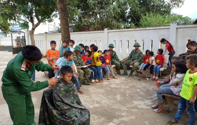 Cán bộ, chiến sỹ Trung đoàn 880 cắt tóc cho các em học sinh trường tiểu học (thành phố Lai Châu). 