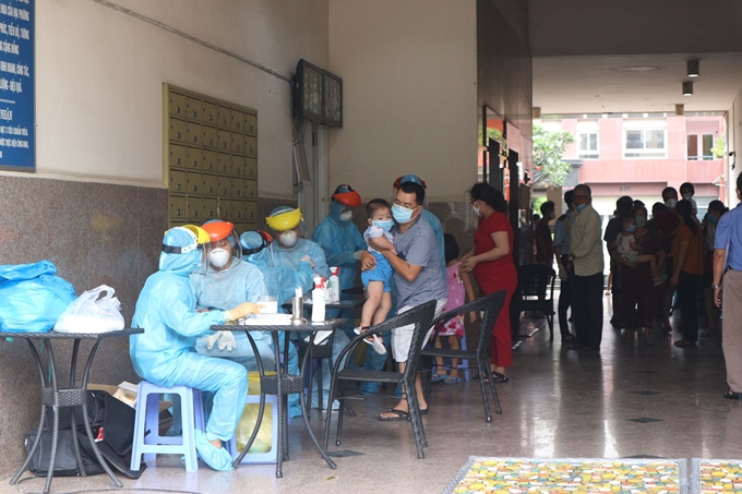 Nhân viên y tế lấy mẫu sàng lọc COVID-19 cho cư dân tại 1 chung cư ở TP.Hồ Chí Minh. (Ảnh: TL)