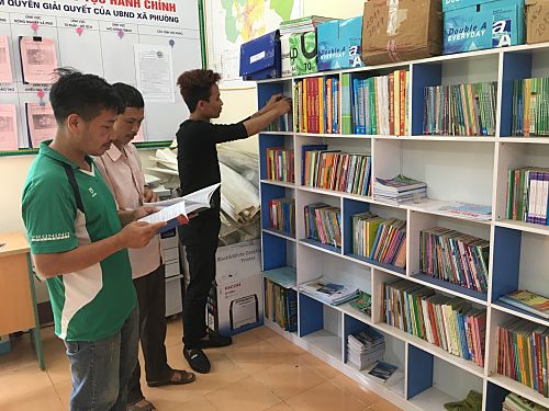 Người dân tìm hiểu Luật Đất đai qua Tủ sách pháp Luật tại xã Phúc Khoa, huyện Than Uyên.