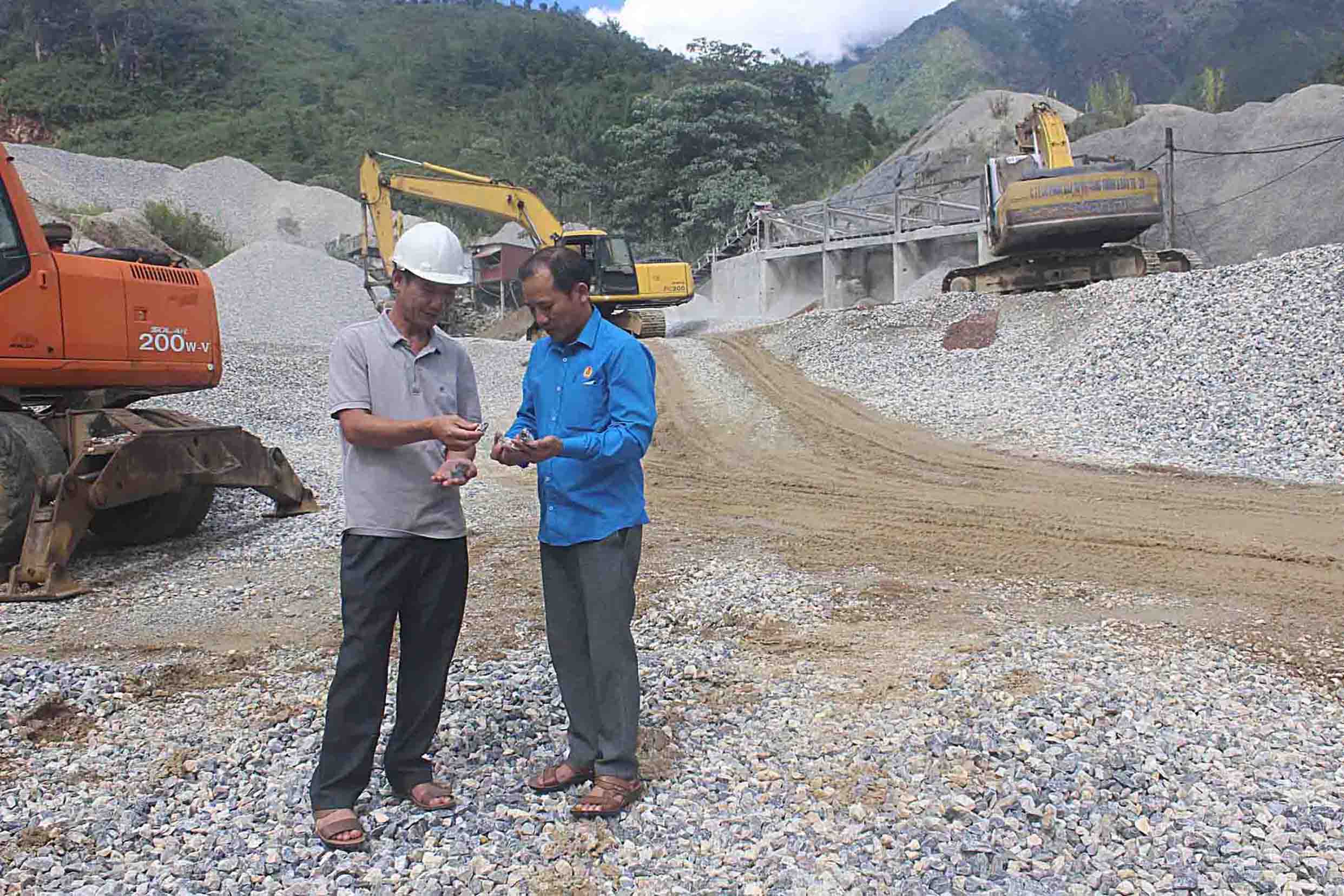 Ông Chu Đình Chí - Chủ tịch Hội Đồng Quản trị, Giám đốc HTX Dịch vụ Cơ khí Mường Lự (người bên trái) kiểm tra sản phẩm đá xây dựng trước khi xuất bán.