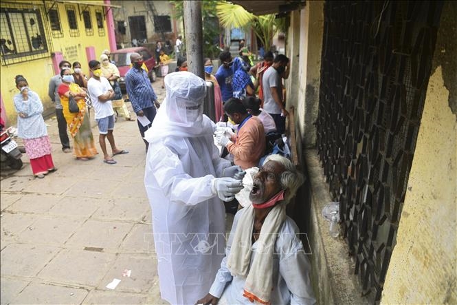 Nhân viên y tế lấy mẫu dịch xét nghiệm COVID-19 cho người dân tại Mumbai, Ấn Độ, ngày 12/10/2020. Ảnh: AFP/TTXVN 