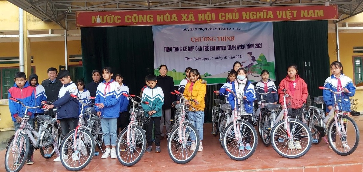 Lãnh đạo Sở Lao động, thương binh & xã hội tỉnh, huyện Than Uyên trao xe đạp cho học sinh.