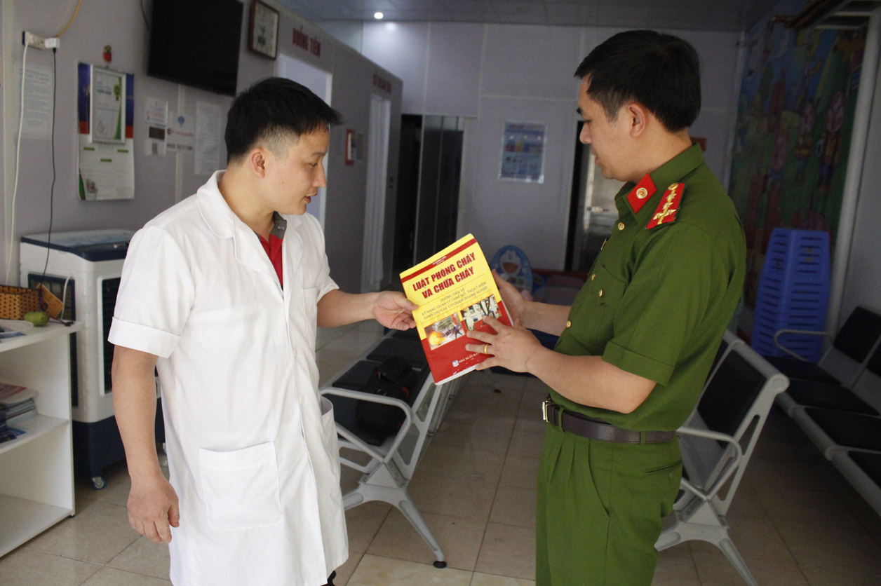 Cán bộ Phòng Cảnh sát PCCC & CNCH (Công an tỉnh) xem cuốn tài liệu các đối tượng “lừa” gửi đến cho anh Nguyễn Mạnh Hùng, Trung tâm tư vấn tiêm chủng và dinh dưỡng - ABHV (phường Đoàn Kết, thành phố Lai Châu). 