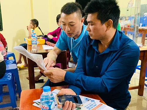 Cán bộ BHXH tỉnh hướng dẫn người dân tổ 14, phường Tân Phong đăng ký sử dụng hình ảnh thẻ BHYT trên ứng dụng VssID.