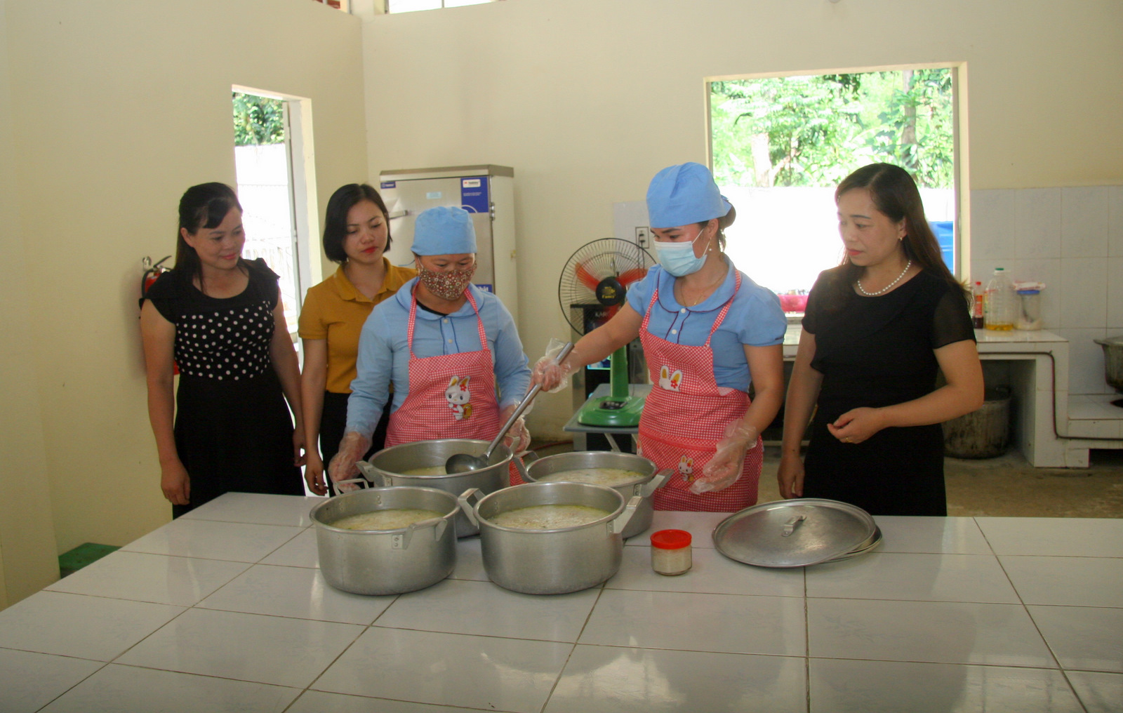 Ban Giám hiệu Trường Mầm non xã Mường Kim (huyện Than Uyên) kiểm tra việc nấu ăn của nhân viên nhà bếp.