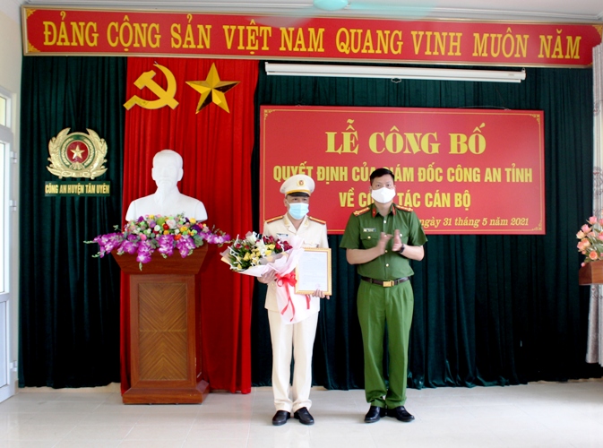 Đại tá Phạm Hải Đăng - Phó giám đốc Công an tỉnh trao quyết định và tặng hoa cho Thiếu tá Vũ Văn Lân – Phó Giám đốc Công an huyện Tân Uyên. 