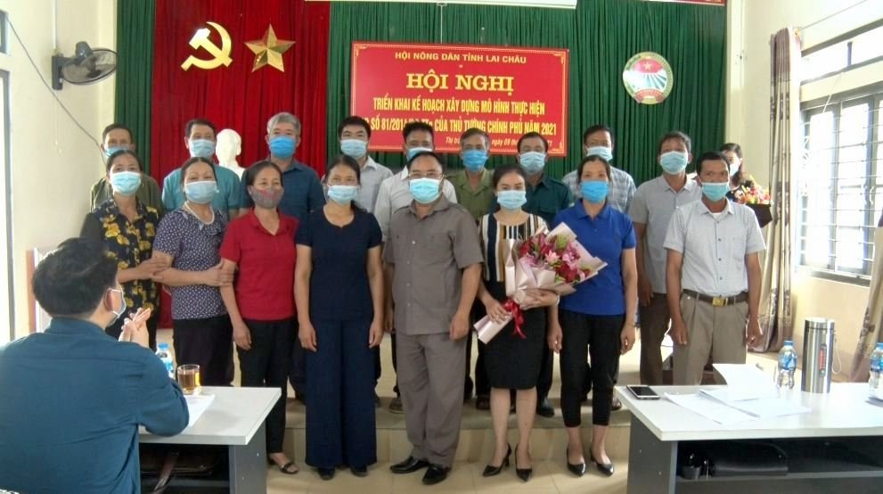 Đồng chí Mùa A Trừ - Chủ tịch HND tỉnh tặng hoa Ban Chủ nhiệm Câu lạc bộ “Nông dân với pháp luật” thị trấn Than Uyên.