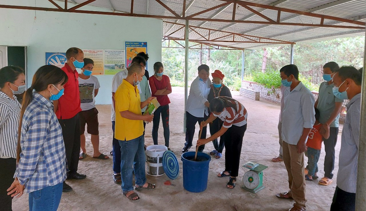 Đại biểu và người dân tham quan phần thực hành hướng dẫn pha sinh khối men vi sinh xử lý phân gia súc, gia cầm tại bản Nậm Sáng, xã Phúc Than (huyện Than Uyên).