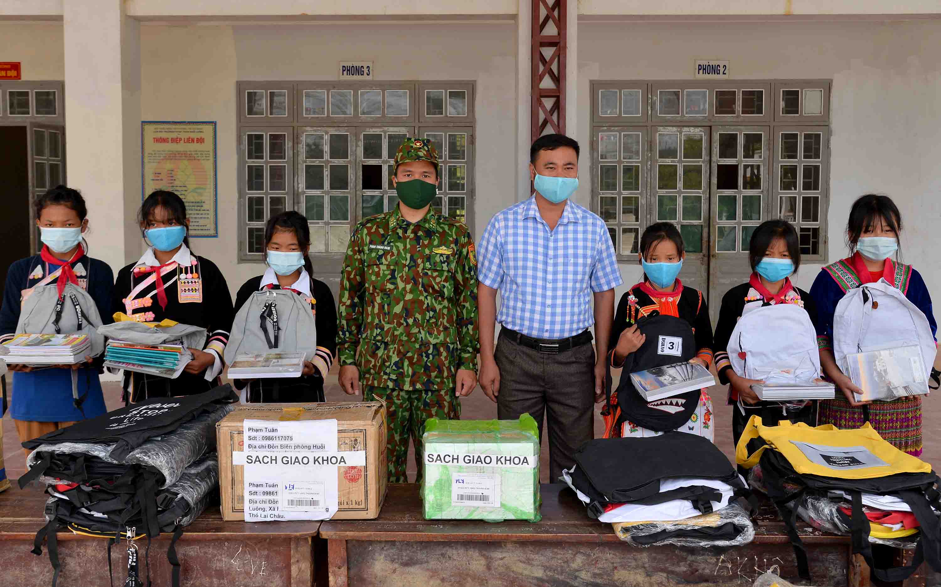 Cán bộ Đồn Biên phòng Huổi Luông trao sách giáo khoa, ba lo, đồ dùng học tập cho học sinh trường THCS xã Huổi Luông (huyện Phong Thổ). 