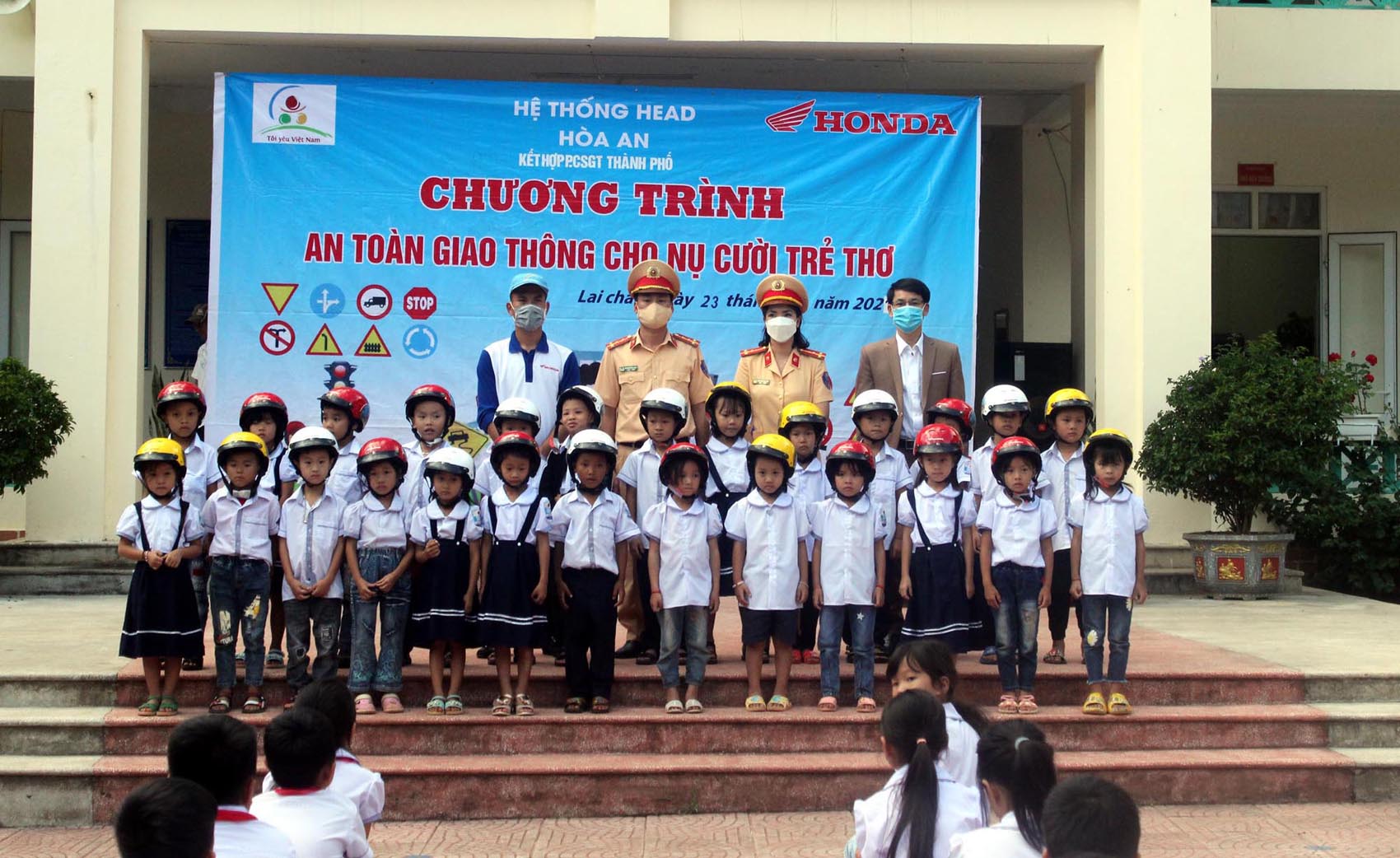 Đại diện Công an thành phố Lai Châu, Trường Tiểu học San Thàng, Honda Hòa An trao mũ bảo hiểm cho học sinh.