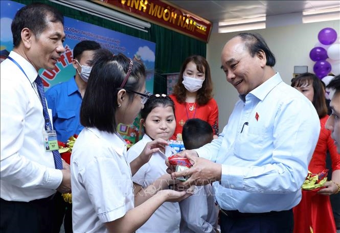  Chủ tịch nước Nguyễn Xuân Phúc tặng quà cho trẻ khuyết tật. Ảnh An Đăng/TTXVN.