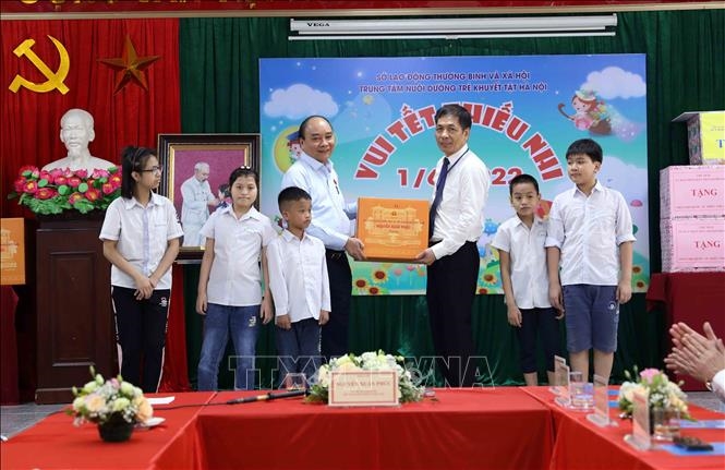 Chủ tịch nước Nguyễn Xuân Phúc tặng quà cho Trung tâm Nuôi dưỡng trẻ khuyết tật Hà Nội. Ảnh: An Đăng - TTXVN 
