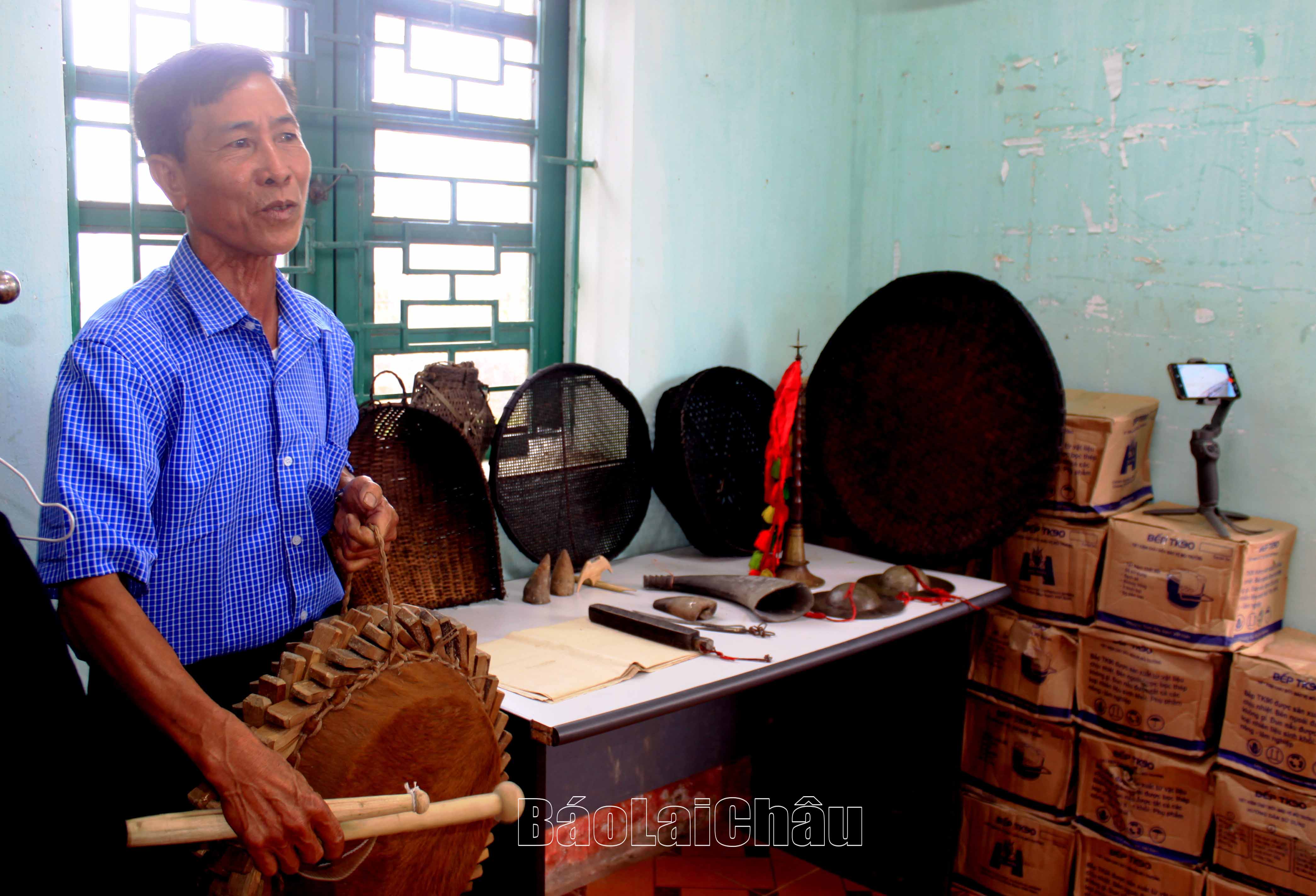 Ông Lò Văn Lai giới thiệu các vật dụng từ thời xa xưa của người dân bản cũ.
