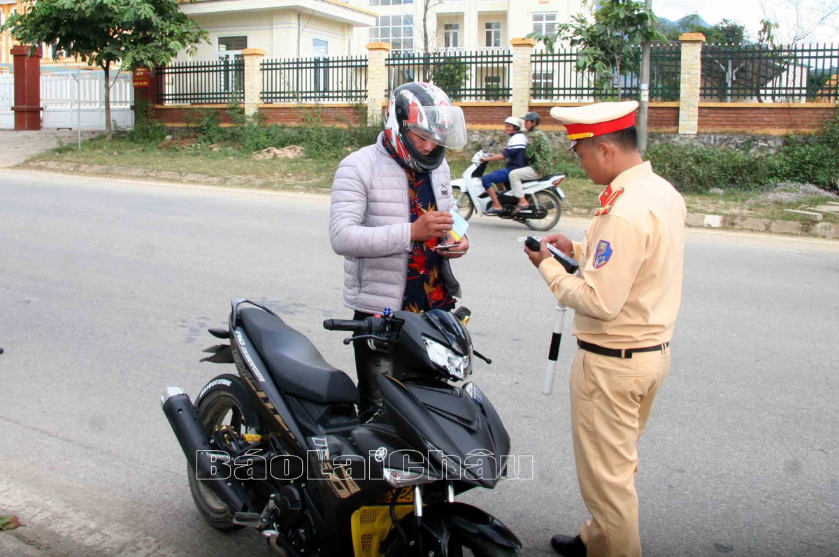 cán bộ Đội Cảnh sát Giao thông trật tự - Công an huyện Tân Uyên kiểm tra giấy phép lái xe của người điều khiển phương tiện khi tham gia giao thông
