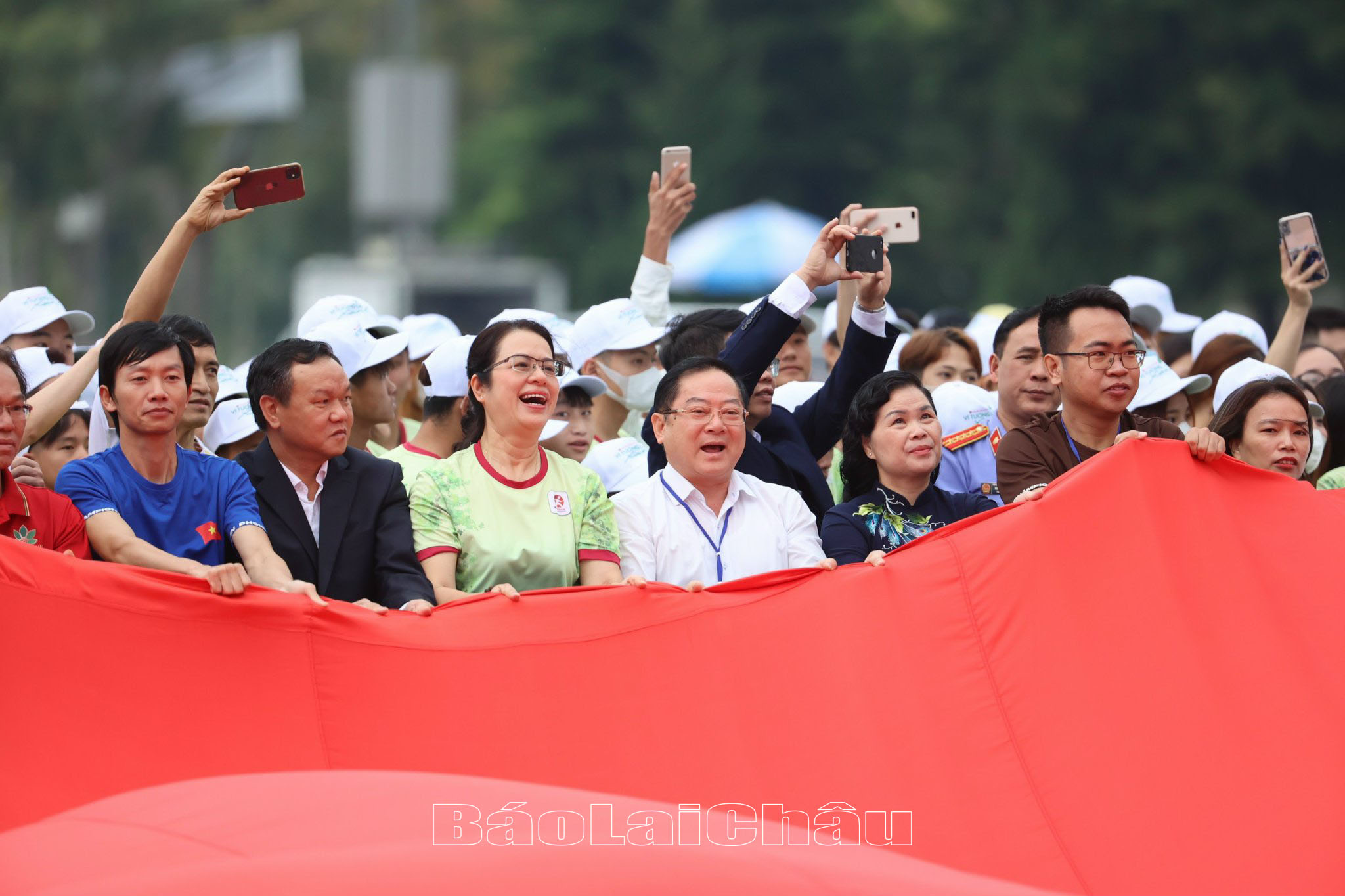 Các đại biểu hoà mình cầm lá cờ Tổ quốc dài 540m2 đại diện cho 54 dân tộc trên đất nước Việt Nam. 