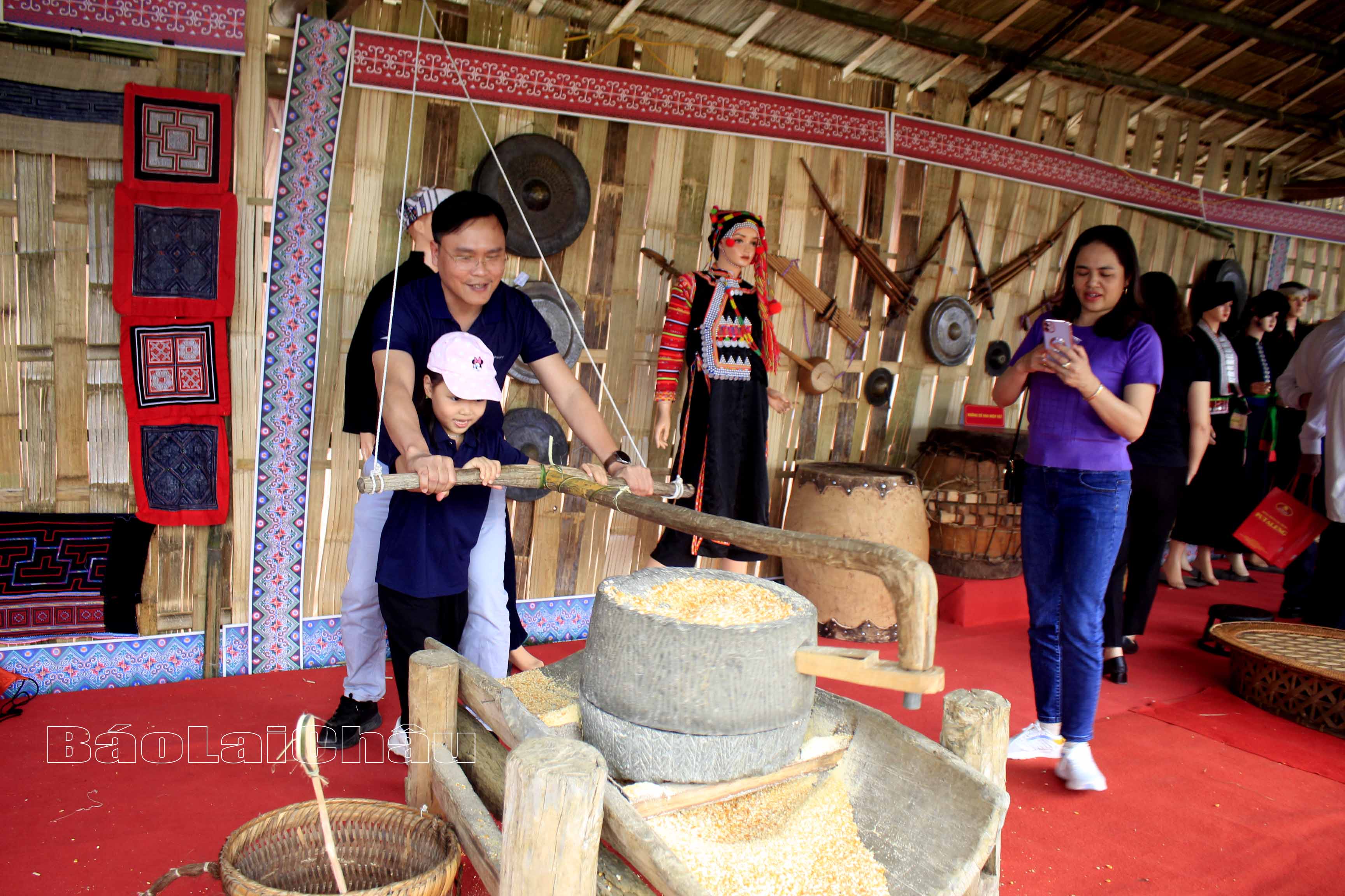 Du khách trải nghiệm xay ngô - hoạt động đặc trưng trong văn hoá của người dân tộc Mông. 