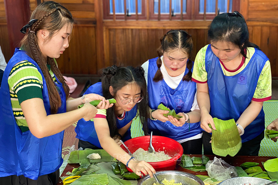 Đội lưu học sinh Lào tham gia gói bánh chưng. 