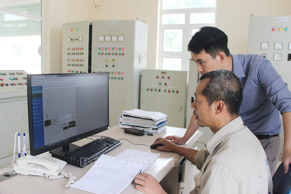 Anh Nam và công nhân Nhà máy nước thành phố Lai Châu kiểm tra áp lực nước trên hệ thống qua máy tính.