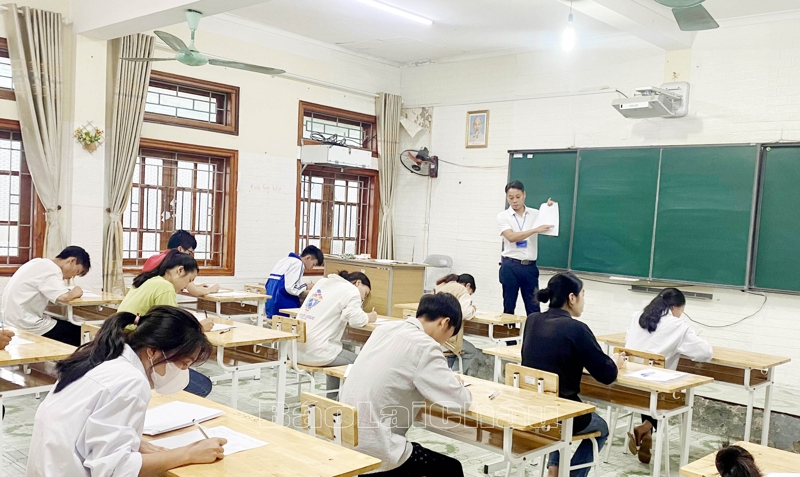 giám thị tại điểm thi Trường THPT huyện Tân Uyên hướng dẫn thí sinh điền thông tin vào giấy thi.