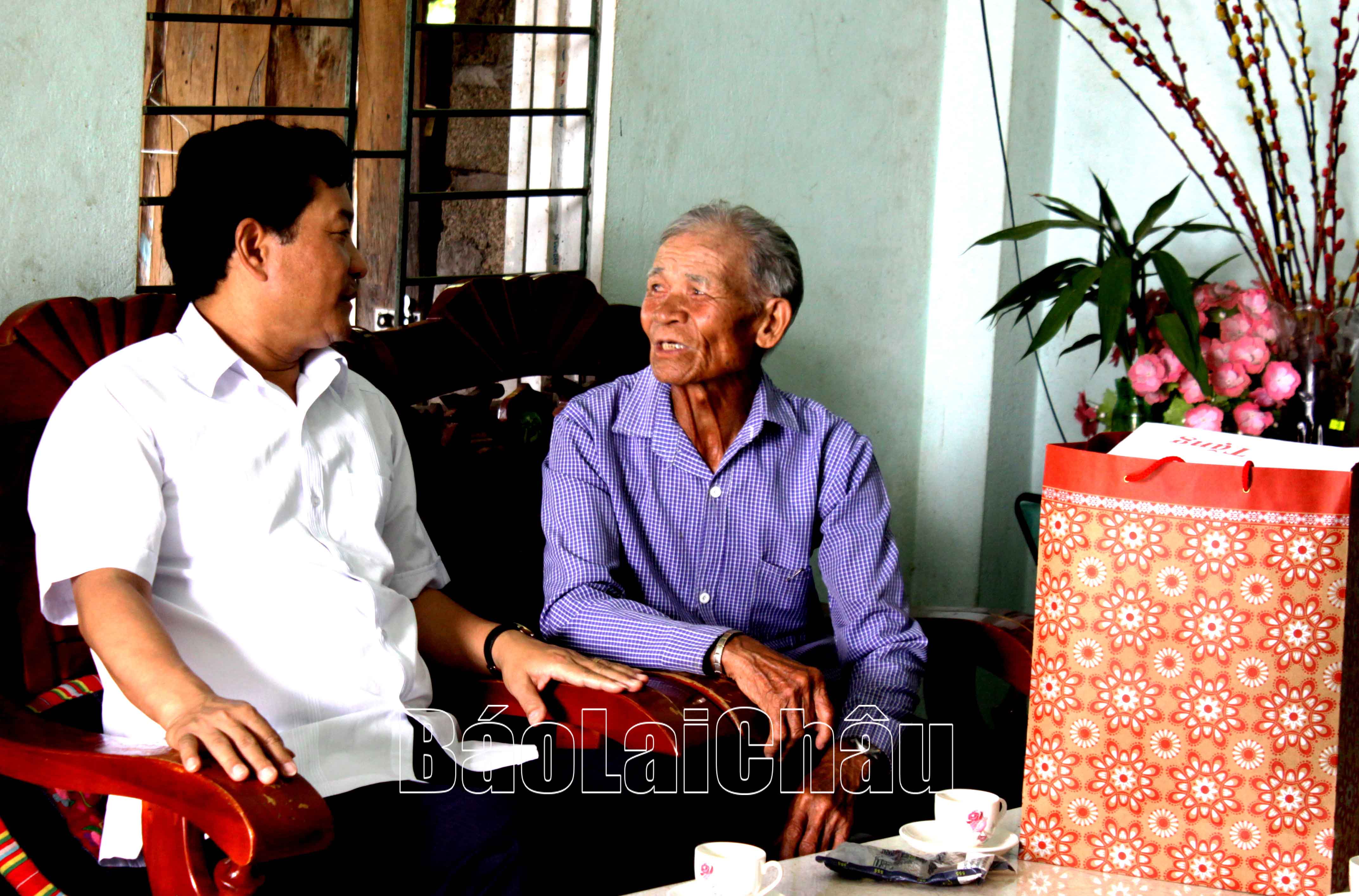 Đồng chí Chu Lê Chinh ân cần thăm hỏi ông Hoàng Văn Tỏi (bố liệt sỹ) ở bản Nà Pè, xã Mường Khoa. 