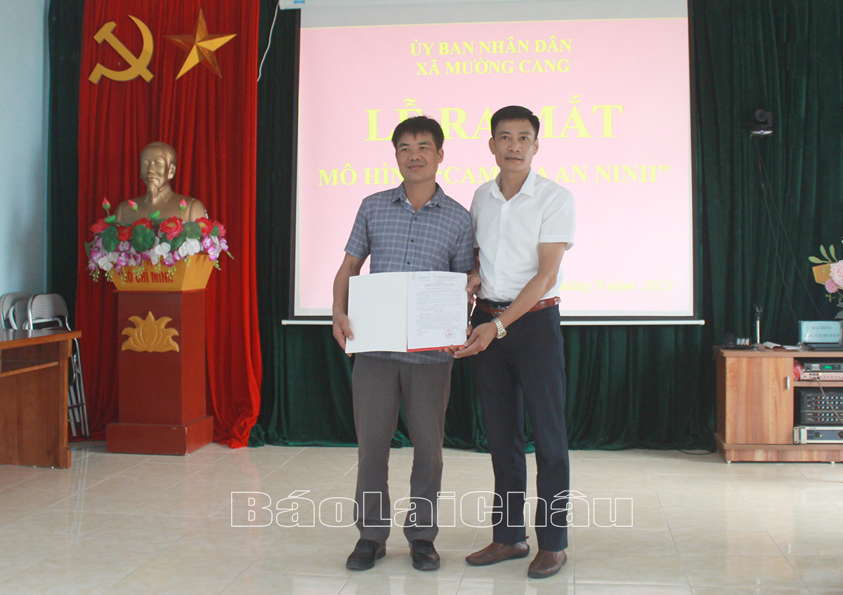 Đồng chí Nguyễn Tự Trọng - Chủ tịch UBND xã Mường Cang trao quyết định công nhận mô hình “Camera an ninh” cho đại diện các bản. 