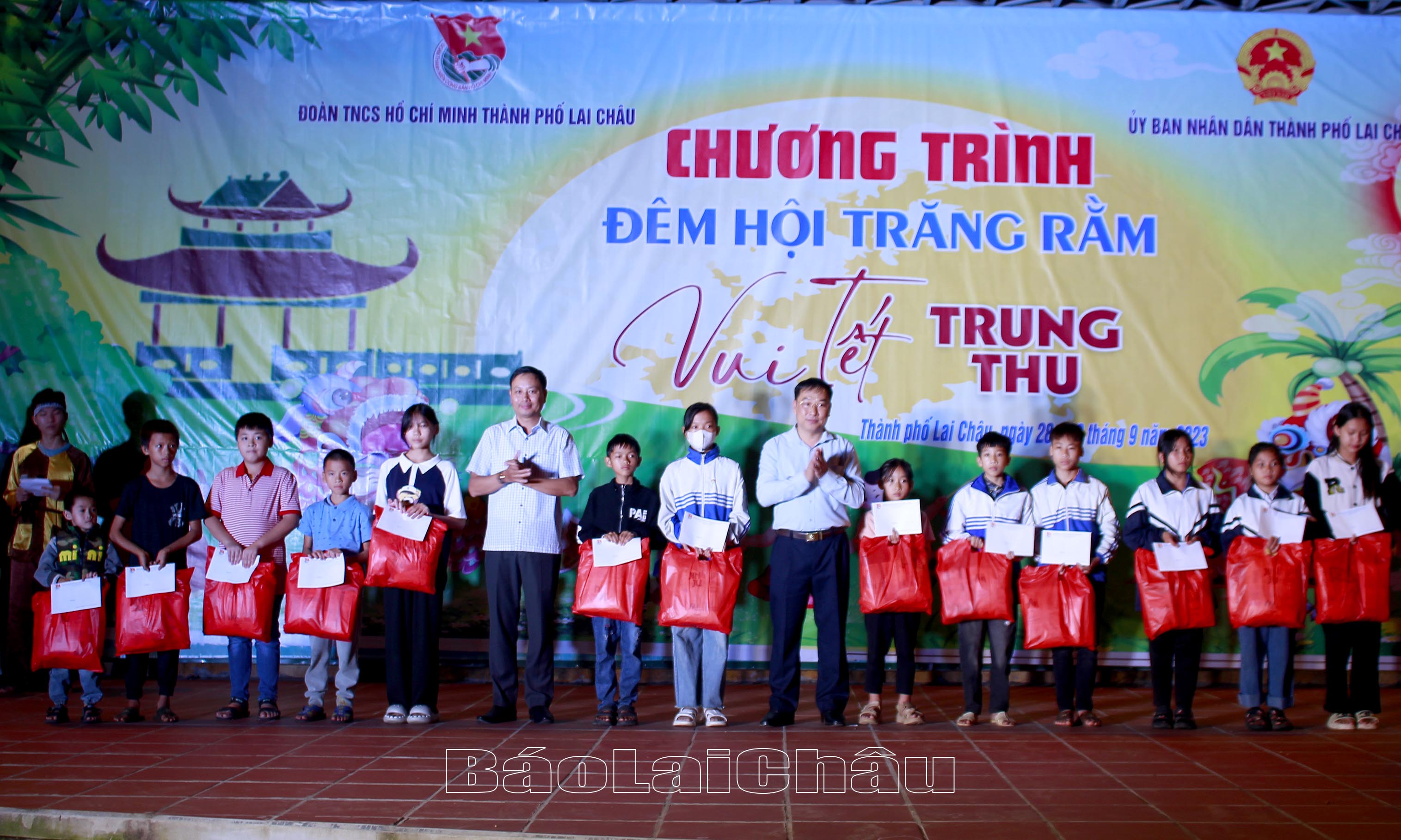 Các đồng chí: Tống Thanh Bình- Bí thư Thành ủy; Trần Đình Tiến - Phó Chủ tịch UBND thành phố Lai Châu tặng quà cho các em nuôi của Đoàn. 