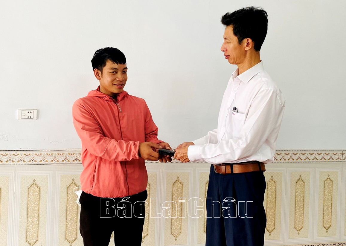Anh Lò Văn Sơn nhận lại tài sản bị đánh rơi từ anh Nguyễn Xuân Biển (bên phải ảnh). 