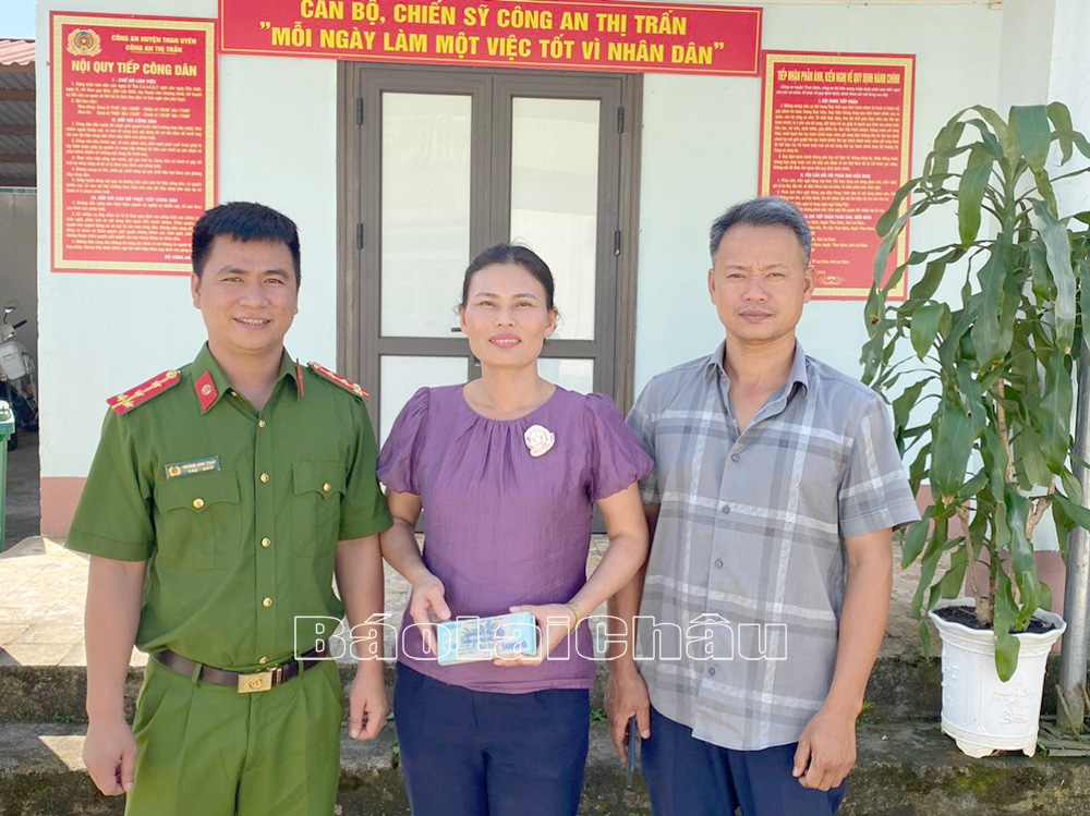 Đại diện Công an thị trấn Than Uyên trao trả lại số tiền chuyển khoản nhầm cho chị Nguyễn Thị Hằng. 