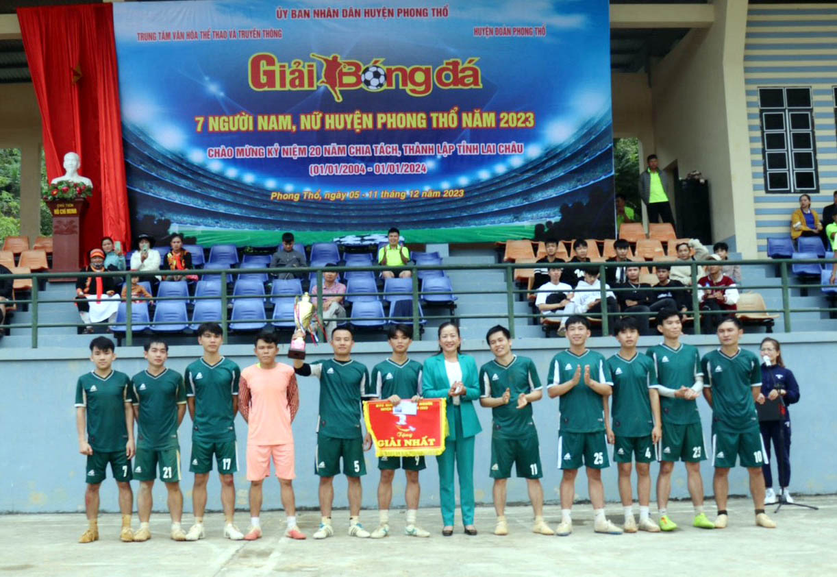 Đồng chí Mai Thị Hồng Sim - Phó Chủ tịch UBND huyện Phong Thổ trao cup và giải nhất cho đội bóng đá nam xã Mường So.