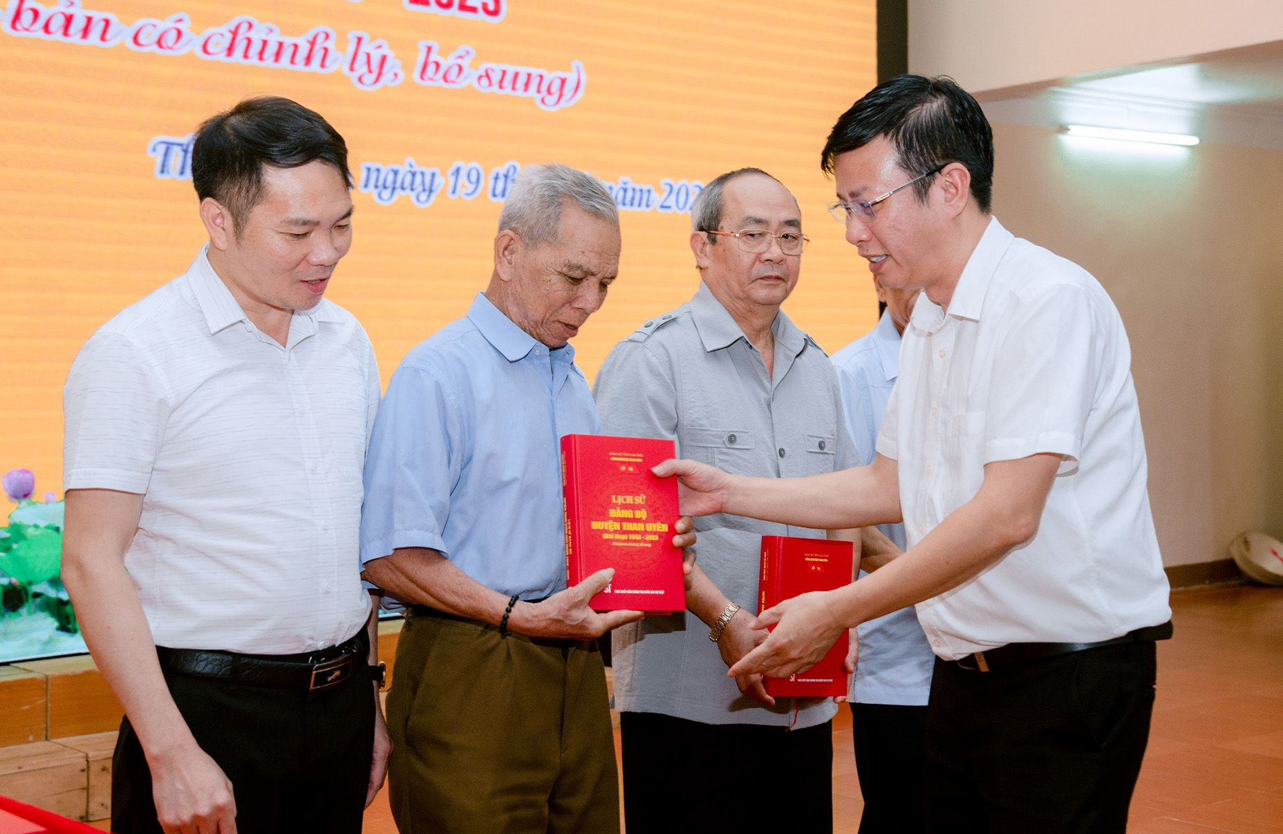 Đồng chí Nguyễn Văn Thăng - Phó Bí thư Huyện ủy, Chủ tịch UBND huyện Than Uyên tặng cuốn lịch sử Đảng bộ huyện cho các đại biểu.