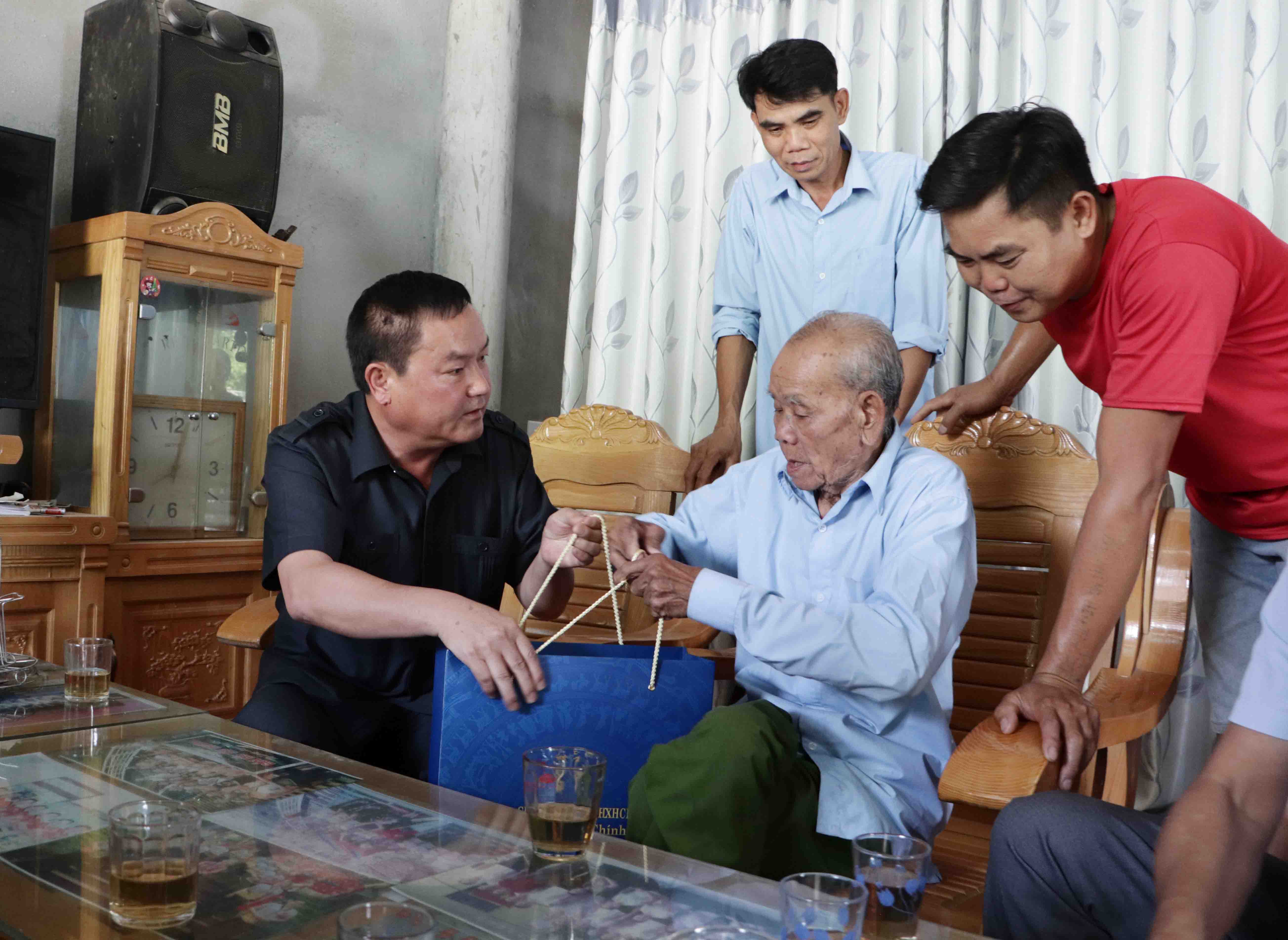 Đồng chí Giàng A Tính - Ủy viên Ban Thường vụ Tỉnh ủy, Phó Chủ tịch UBND tỉnh tặng quà ông Teo Văn Pưng ở bản Vàng Pheo (xã Mường So).