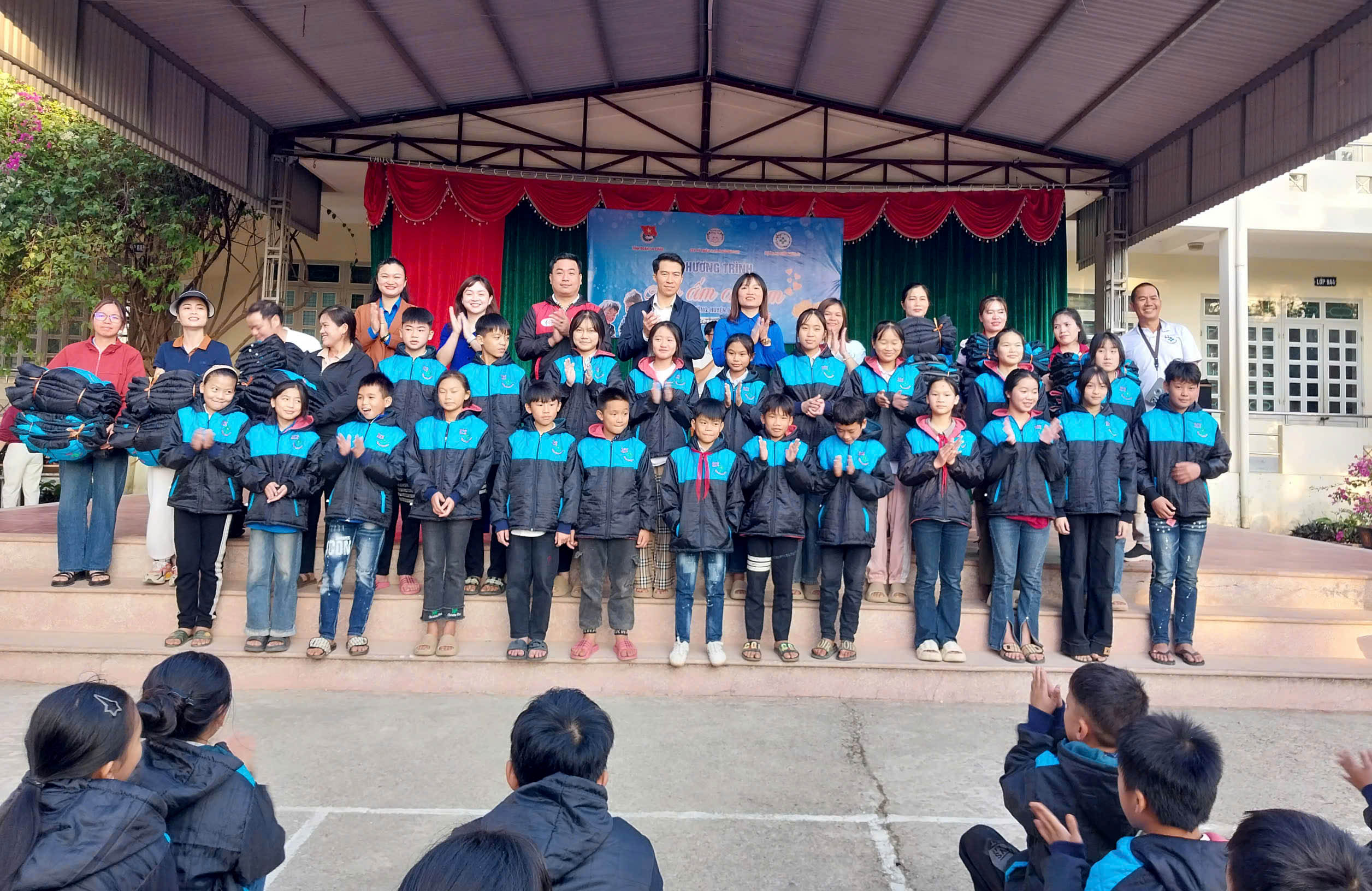Các đại biểu trao áo ấm cho học sinh trường THCS xã Phúc Than (huyện Than Uyên).
