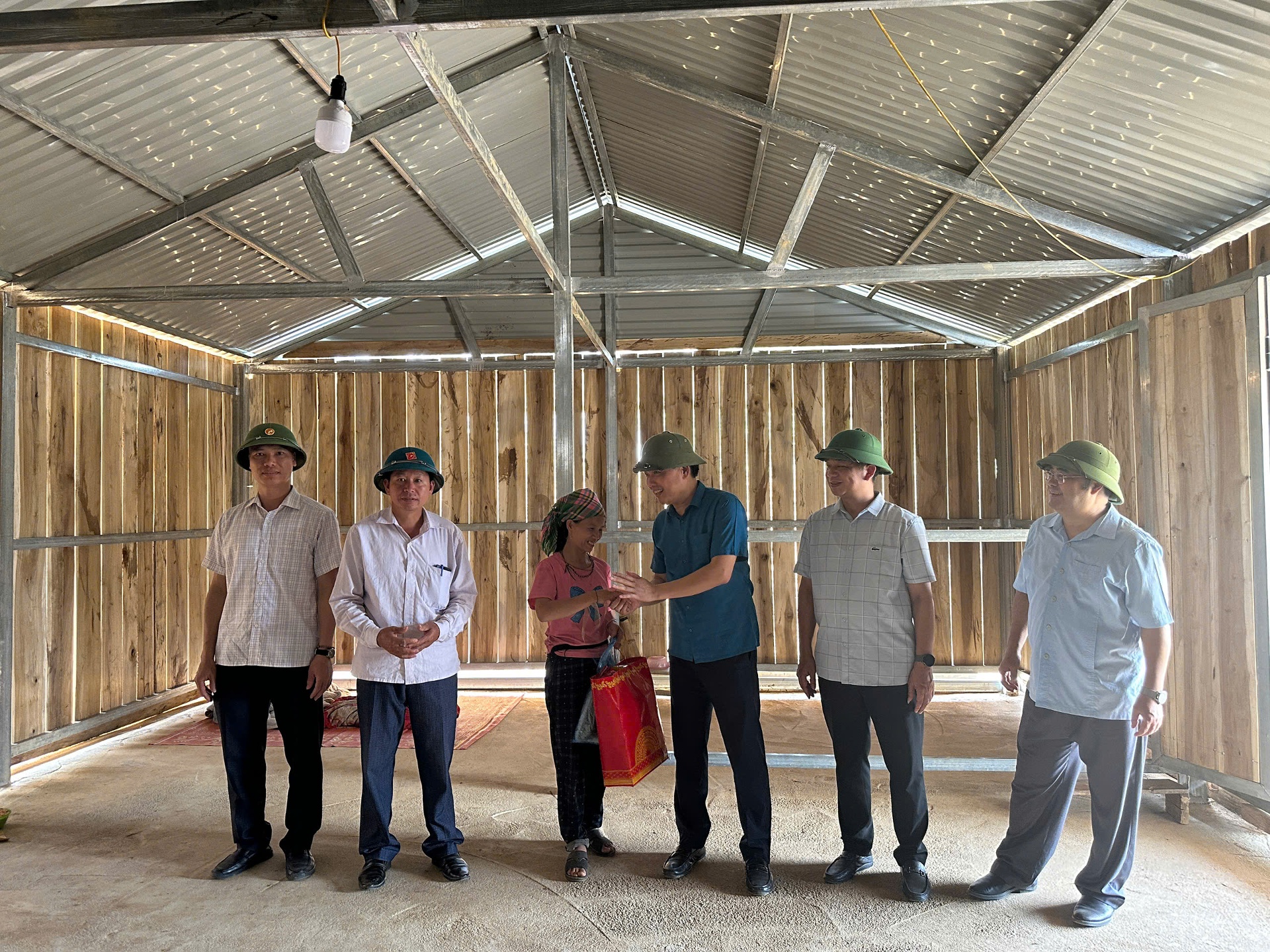Tổ kiểm tra tặng quà người dân xã Pú Đao thuộc diện được hỗ trợ xóa nhà tạm.
