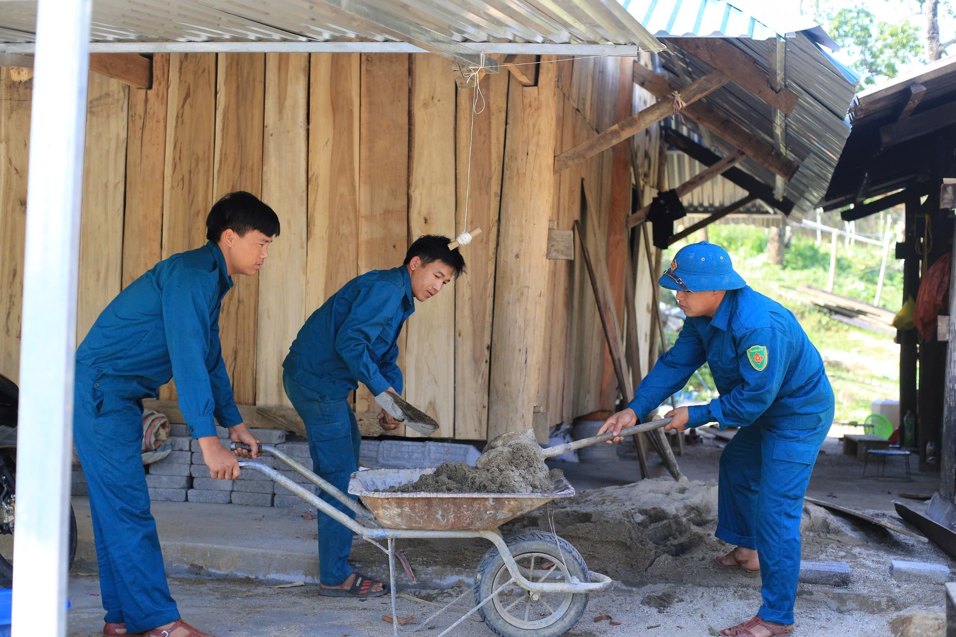 Lực lượng dân quân xã Pú Đao giúp người dân bản Nậm Đoong xoá nhà tạm, nhà dột nát.
