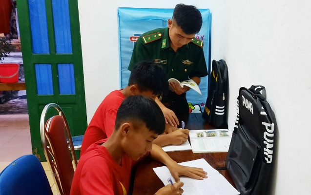  Cán bộ Đồn Biên phòng Thu Lũm dạy các em học ngoài giờ lên lớp. 