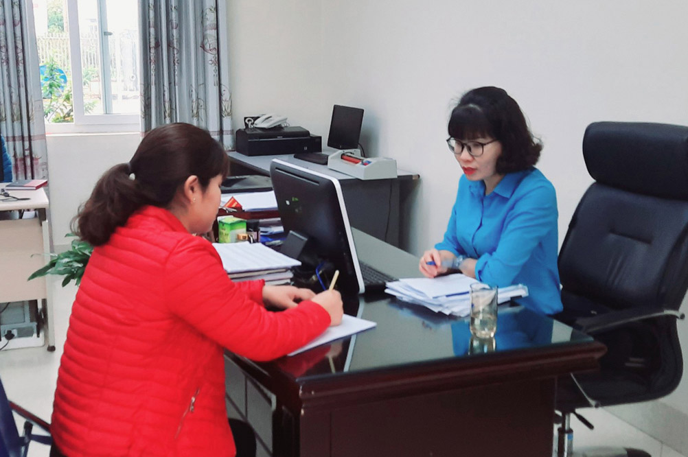 Chị Lệ (bên phải) hướng dẫn khách hàng thủ tục hợp đồng dịch vụ cấp nước.