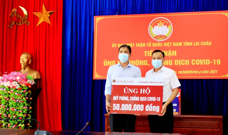Đại diện lãnh đạo Chi nhánh Ngân hàng Nông nghiệp và Phát triển nông thôn tỉnh trao ủng hộ Quỹ phòng, chống Covid-19 tỉnh. 