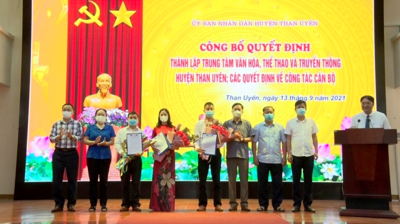 Các đồng chí Thường trực Huyện ủy, HĐND, UBND, Ban Tổ chức Huyện ủy Than Uyên trao Quyết định, tặng hoa chúc mừng lãnh đạo Trung tâm Văn hóa, Thể thao và Truyền thông huyện.