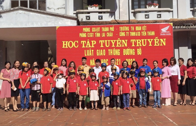Đại diện các đơn vị trao mũ bảo hiểm cho học sinh.