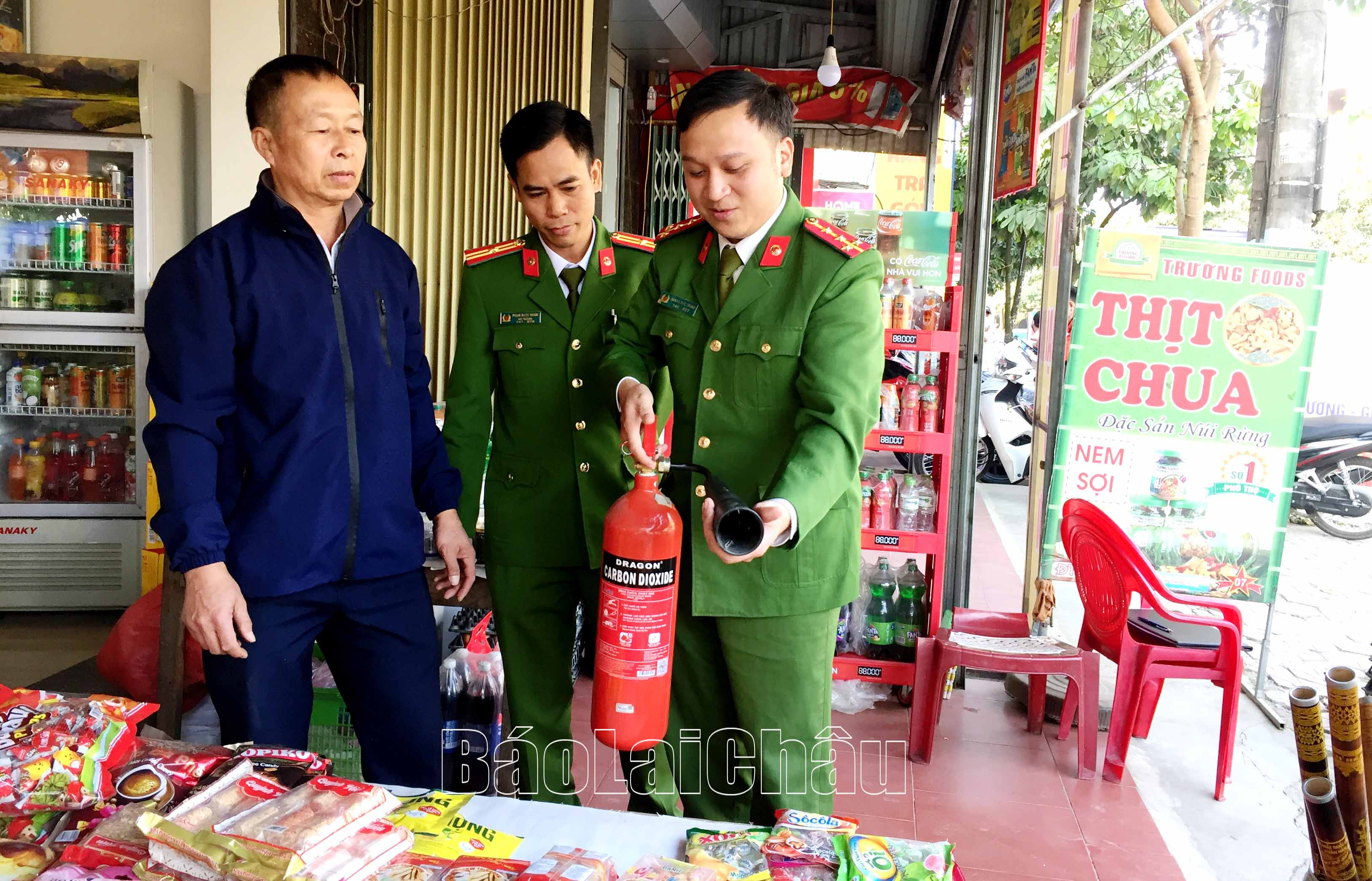Lực lượng Công an thị trấn kiểm tra kết hợp hướng dẫn các hộ kinh doanh tại khu vực chợ cách sử dụng bình chữa cháy.