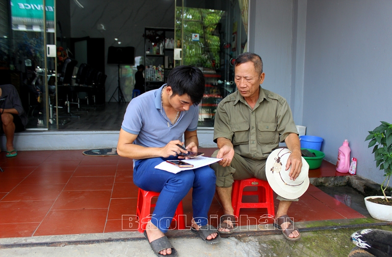 Người dân ở bản Trung Tâm (thị trấn Tam Đường) giúp nhau kích hoạt tài khoản định danh điện tử mức độ 2 trên điện thoại thông minh.